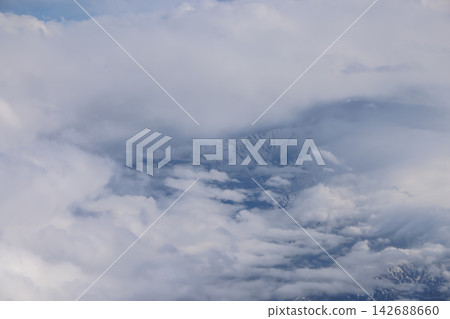 Cloud opening revealing mountain landscape below Cloud opening revealing mountain landscape below 142688660