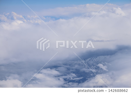 Cloud opening revealing mountain landscape below Cloud opening revealing mountain landscape below 142688662