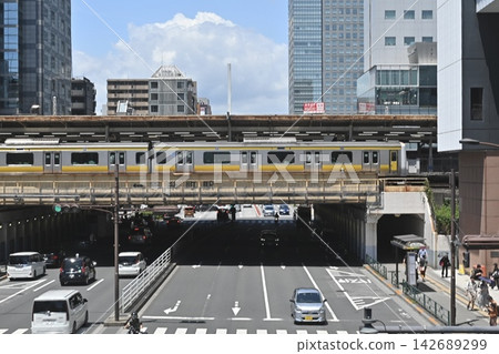 The JR Chuo-Sobu Line runs along the elevated tracks of Iidabashi Station on a sunny day, with the city skyline of central Tokyo in the background. The JR Chuo-Sobu Line runs along the elevated tracks of Iidabashi Station on a sunny day, with the city skyline of central Tokyo in the background. 142689299