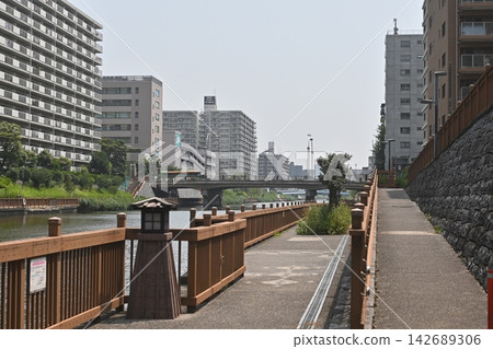 沿著河流而建的美麗水濱露台,可欣賞城市公寓大樓的景色。 沿著河流而建的美麗水濱露台,可欣賞城市公寓大樓的景色。 142689306