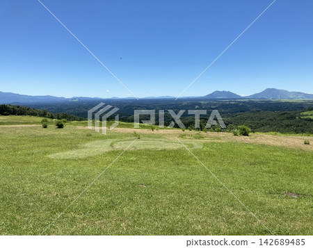 A vast mountain range and blue sky viewed from a sunny plateau. A vast mountain range and blue sky viewed from a sunny plateau. 142689485