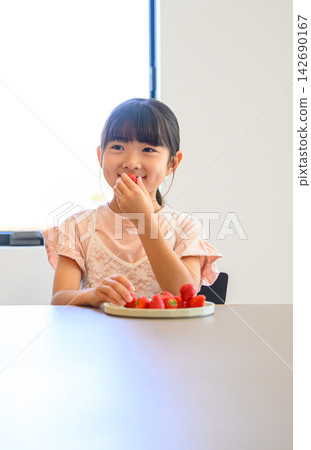 A girl happily eating a strawberry. A girl happily eating a strawberry. 142690167