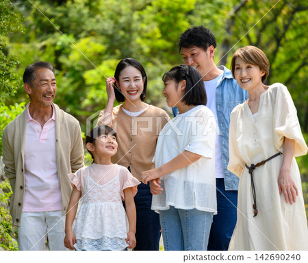 A multi-generational family chatting with smiles on their faces. A multi-generational family chatting with smiles on their faces. 142690240