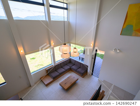 A modern living room with large windows and a sofa. A modern living room with large windows and a sofa. 142690247