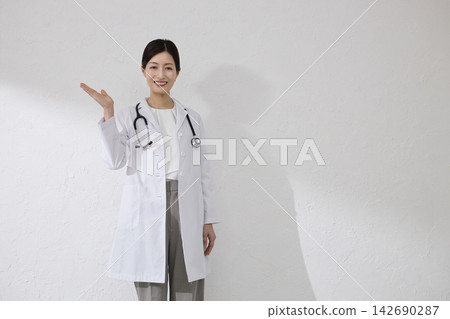 Female doctor wearing white coat Female doctor wearing white coat 142690287