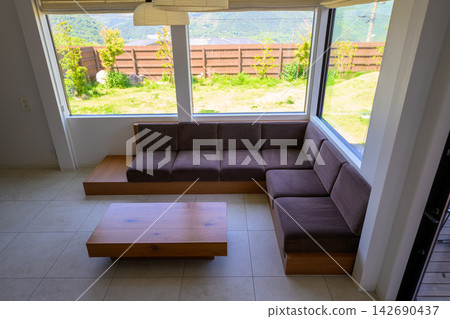 The living room, with its large windows overlooking the lush garden. The living room, with its large windows overlooking the lush garden. 142690437