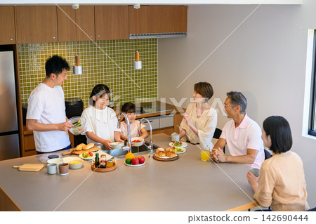 一家六口在廚房準備餐點時互相交流。 一家六口在廚房準備餐點時互相交流。 142690444