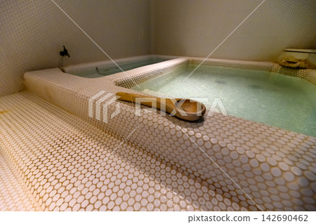 A tiled bathtub and ladle A tiled bathtub and ladle 142690462