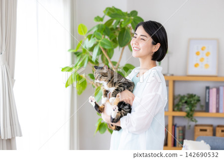 A woman holding her pet cat. A woman holding her pet cat. 142690532