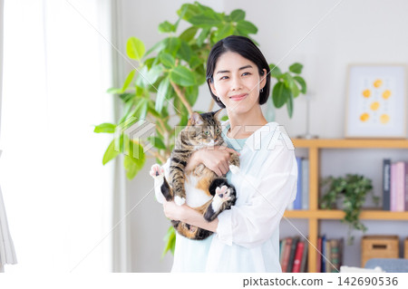 A woman holding her pet cat. A woman holding her pet cat. 142690536