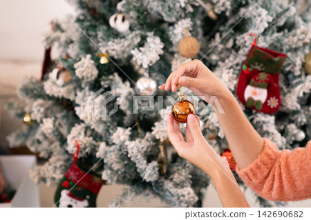 Elderly husband and wife hanging ornaments on small Christmas tree Elderly husband and wife hanging ornaments on small Christmas tree 142690682