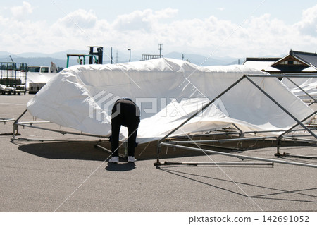 Woman assembling a tent Woman assembling a tent 142691052