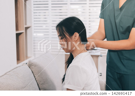 Professional doctor performing a spinal examination on a female patient. Professional doctor performing a spinal examination on a female patient. 142691417