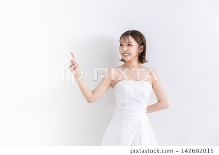一位身穿婚紗的年輕女子在白色背景前擺姿勢拍照。 一位身穿婚紗的年輕女子在白色背景前擺姿勢拍照。 142692015