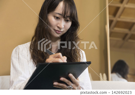 一位年輕女子在美容院填寫醫療問卷。 一位年輕女子在美容院填寫醫療問卷。 142692023