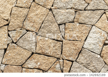 Yellow stone wall with irregular stacked masonry creates a rugged, neutral texture Yellow stone wall with irregular stacked masonry creates a rugged, neutral texture 142692189