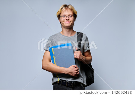 Portrait of smiling teenage student with notebooks and backpack Portrait of smiling teenage student with notebooks and backpack 142692458