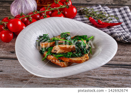 Grilled chicken slices with sauteed spinach in white ceramic bowl, surrounded by cherry tomatoes, garlic, red chili, and thyme on rustic wooden table Grilled chicken slices with sauteed spinach in white ceramic bowl, surrounded by cherry tomatoes, garlic, red chili, and thyme on rustic wooden table 142692674