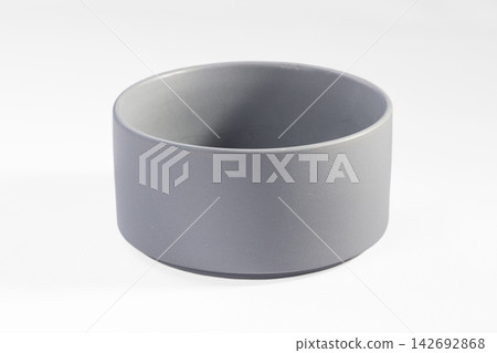Empty round gray ceramic pot or planter on clean white background, minimalist cylindrical design for home decor or product display Empty round gray ceramic pot or planter on clean white background, minimalist cylindrical design for home decor or product display 142692868