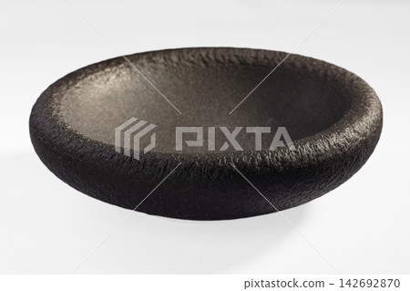 Black textured ceramic bowl with matte finish and subtle metallic sheen, isolated on white background, shallow depth of field Black textured ceramic bowl with matte finish and subtle metallic sheen, isolated on white background, shallow depth of field 142692870