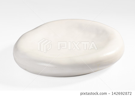 Smooth white ceramic dish with organic oval shape and glossy finish on plain white background 142692872