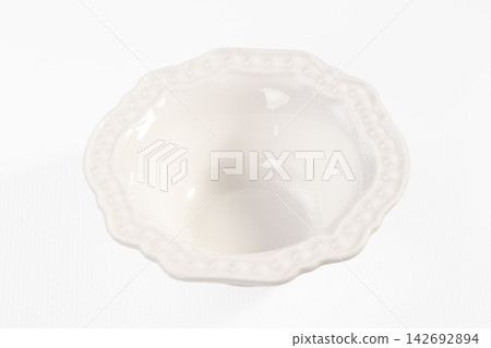 White ceramic bowl with scalloped edge and raised dot pattern, isolated on white background, overhead view White ceramic bowl with scalloped edge and raised dot pattern, isolated on white background, overhead view 142692894