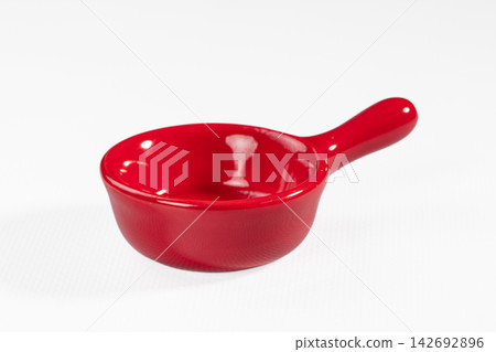 Glossy red ceramic sauce bowl with handle on white background, shallow depth of field, soft studio lighting Glossy red ceramic sauce bowl with handle on white background, shallow depth of field, soft studio lighting 142692896
