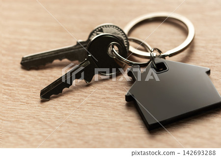 Keys with house shape keychain representing home ownership Keys with house shape keychain representing home ownership 142693288