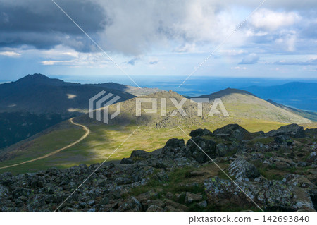 View from the top of the mountain to the valley and the distant road View from the top of the mountain to the valley and the distant road 142693840
