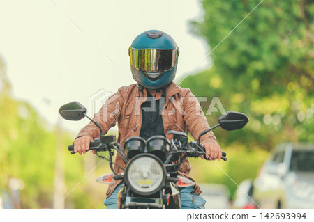 Moto rider wearing a safety helmet on the road Moto rider wearing a safety helmet on the road 142693994