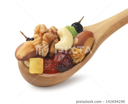 A mix of dried fruits and nuts in a wooden spoon on a white background. Isolated. A mix of dried fruits and nuts in a wooden spoon on a white background. Isolated. 142694290