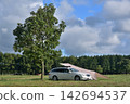 Auto camping next to a single tree in a grassy field Auto camping next to a single tree in a grassy field 142694537