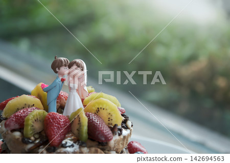 a colorful wedding couple doll cake topper on the food salad cake a colorful wedding couple doll cake topper on the food salad cake 142694563