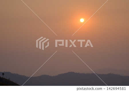 sunset view from the mountain topphoto has focused on a tree branch and partly blur on other subject sunset view from the mountain topphoto has focused on a tree branch and partly blur on other subject 142694581