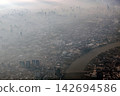 Bangkok city's bird eye view shot from a plane that flight in a morning with warming color of sunrise and some shade from clouds 142694586