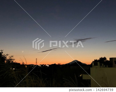 富士山與秋日黃昏中漂浮的彎月。 富士山與秋日黃昏中漂浮的彎月。 142694739
