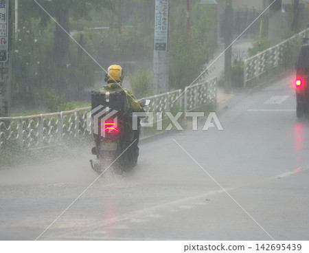 雨中摩托車行駛 雨中摩托車行駛 142695439