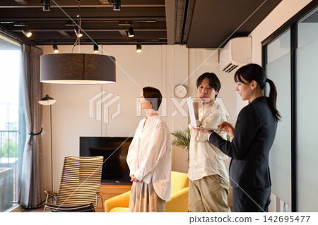 一位女房產經紀人正在帶幾位客戶看房子。 一位女房產經紀人正在帶幾位客戶看房子。 142695477