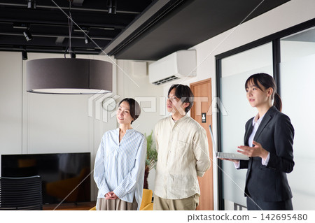 一位女房產經紀人正在帶幾位客戶看房子。 一位女房產經紀人正在帶幾位客戶看房子。 142695480