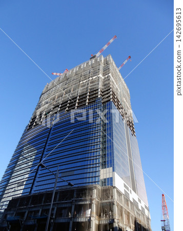 東京車站八重洲出口處正在興建中的高樓建築，背景是冬日的藍天。 142695613