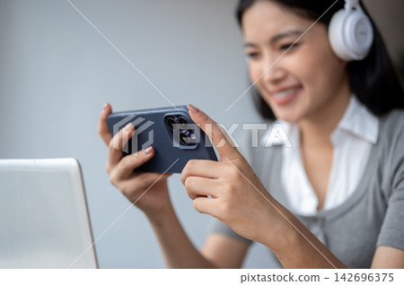 Smiling Asian Woman Watching Video On Mobile Smartphone Smiling Asian Woman Watching Video On Mobile Smartphone 142696375