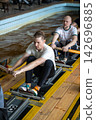 Tired male rowers pushing through powerful catch position during intensive indoor training 142696885