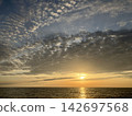 The cirrocumulus clouds bid farewell to the setting sun with a sense of regret. 142697568