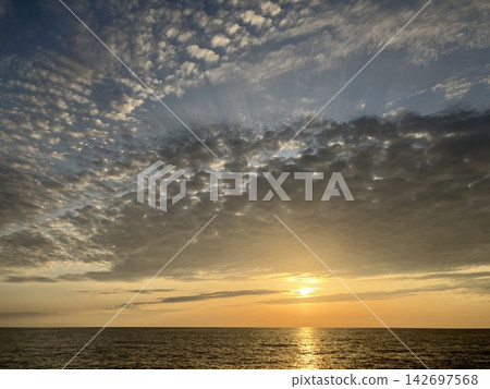 The cirrocumulus clouds bid farewell to the setting sun with a sense of regret. The cirrocumulus clouds bid farewell to the setting sun with a sense of regret. 142697568