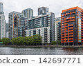 Apartment blocks along dockside in urban district, London, UK 142697771