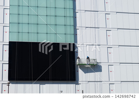 一位負責清潔建築物窗戶的工匠 一位負責清潔建築物窗戶的工匠 142698742