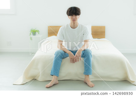 A man who is feeling down in the bedroom A man who is feeling down in the bedroom 142698930