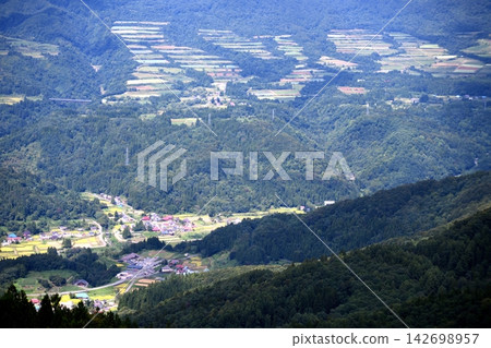 A village nestled in the bountiful autumn mountains 142698957