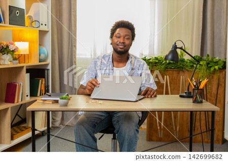 African American young man on home table closing laptop after work and looking confident at camera 142699682