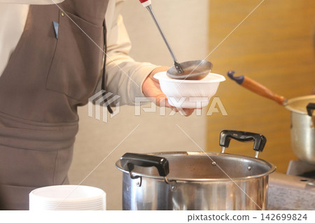A woman serving soup A woman serving soup 142699824